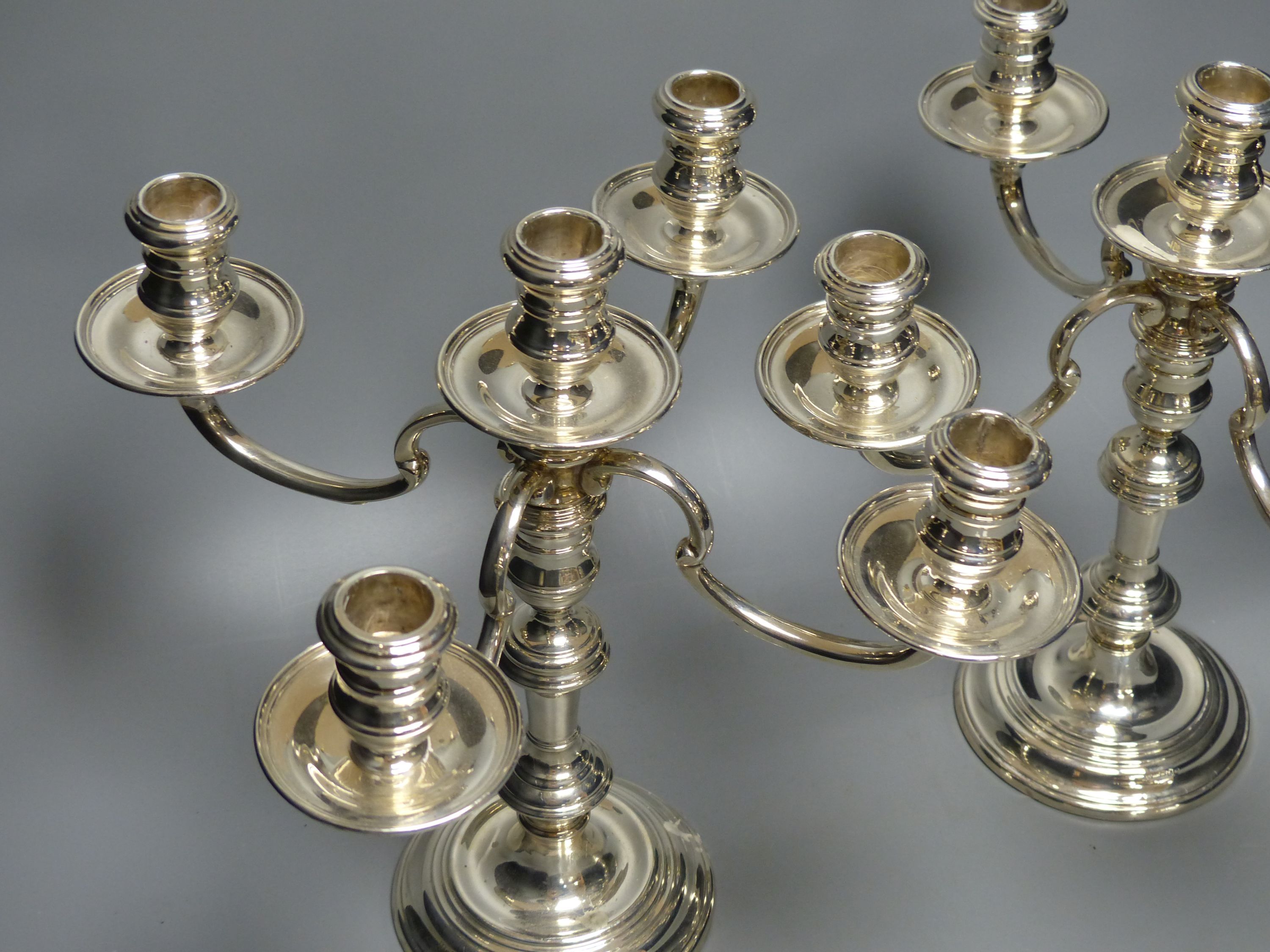 A pair of Georgian style silver four-branch five-light candelabra,